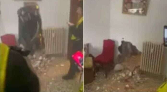 immagine (1200x630 px): Fotografia orizzontale realistica: strada bolognese all’alba, una famiglia accanto ai propri oggetti accatastati sul marciapiede dopo uno sgombero. Sullo sfondo, agenti in divisa e palazzi moderni in ristrutturazione. Atmosfera fredda, luce naturale, contrasto tra dolore umano e ordine urbano.